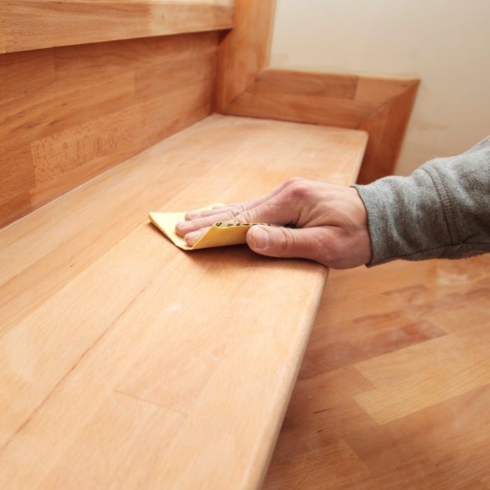 Wood grinding process by sandpaper. The young carpenter works with wood